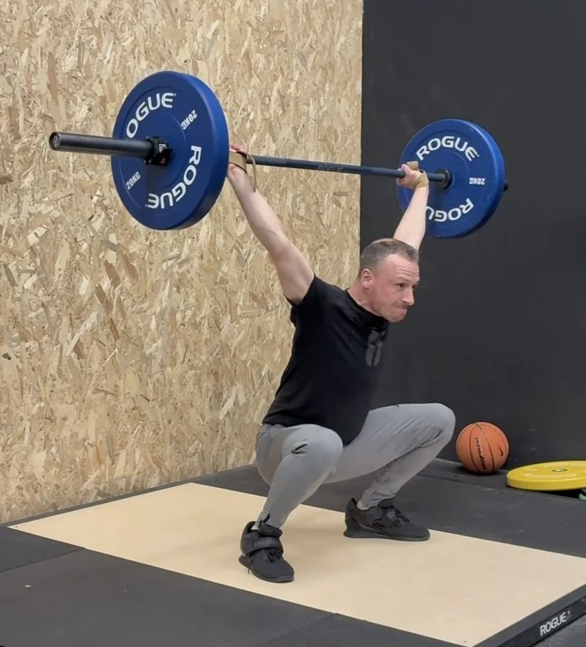 Thijs Honekamp vangt de halter op in de diepe positie van een snatch.