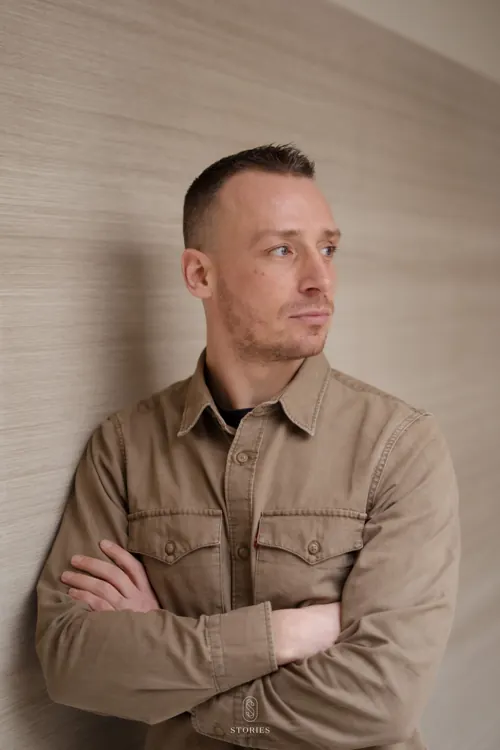 Portret van Thijs bij STORIES, rustig opzij kijkend. Het STORIES-beeldmerk staat onderaan.