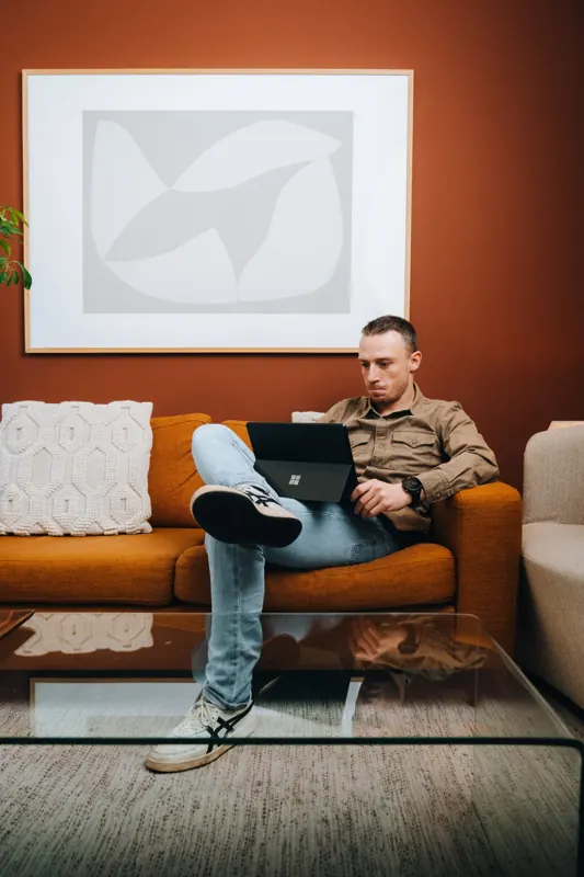 Thijs zittend met zijn laptop op de bank bij STORIES